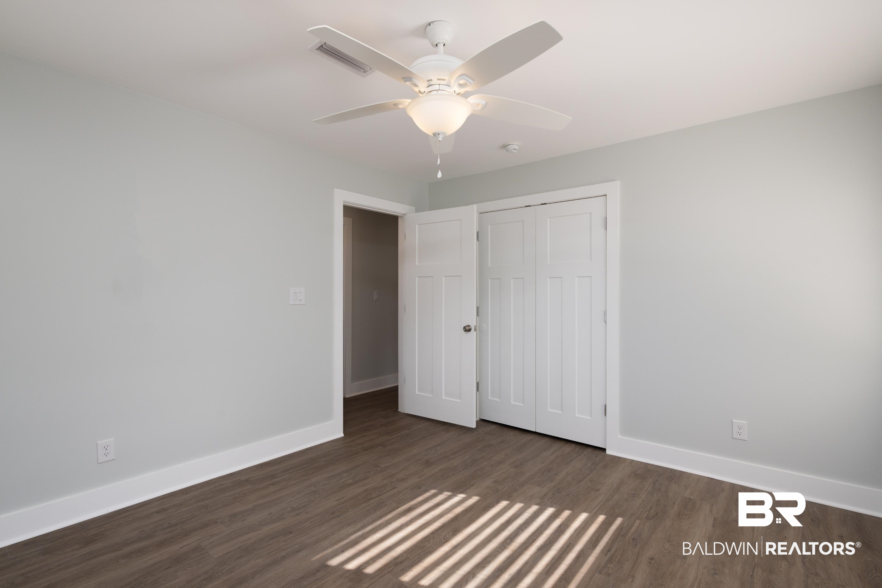 18267 Highway 98 Foley, AL 36535 - Photo 20 of 26 Unfurnished bedroom featuring dark wood-style floors, a ceiling fan, and a closet
