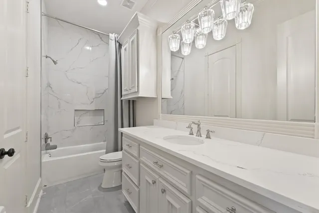 a bathroom with a bathtub shower sink vanity and toilet