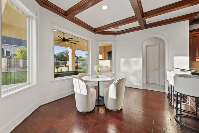 a dining room with wooden floor a glass table and chairs
