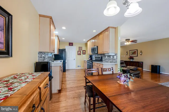 a large kitchen with stainless steel appliances granite countertop a stove a sink dishwasher and a refrigerator