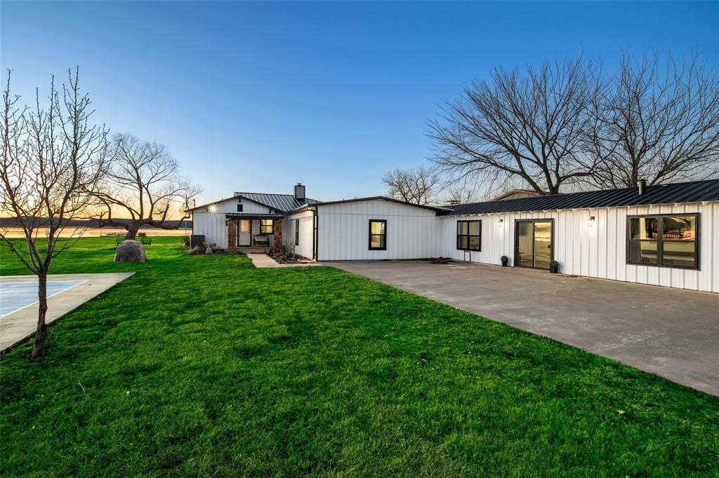 1169 Willow Road Graford, TX 76449 - Photo 2 of 40 a view of a white house in front of a big yard with large trees