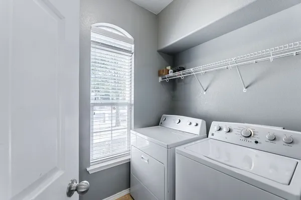 a view of washer and dryer with bathroom in the background