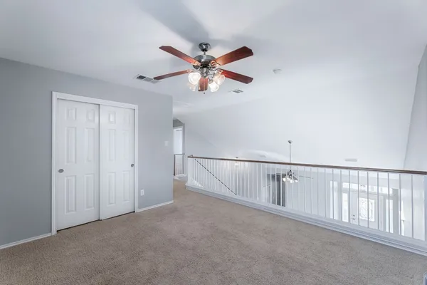 a view of a hallway with a ceiling fan