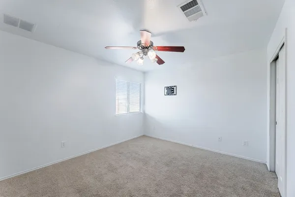 a view of a room with a ceiling fan and a window