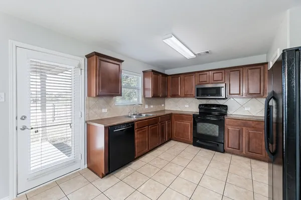 a kitchen with stainless steel appliances granite countertop a refrigerator and a stove top oven