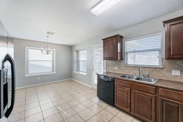 a kitchen with stainless steel appliances granite countertop a sink window and cabinets