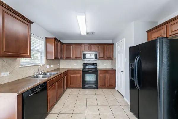 a kitchen with stainless steel appliances granite countertop a refrigerator and a sink