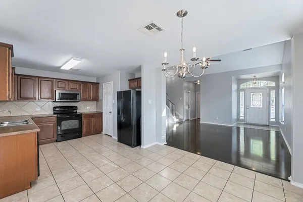 a kitchen with stainless steel appliances kitchen island granite countertop a refrigerator and a sink