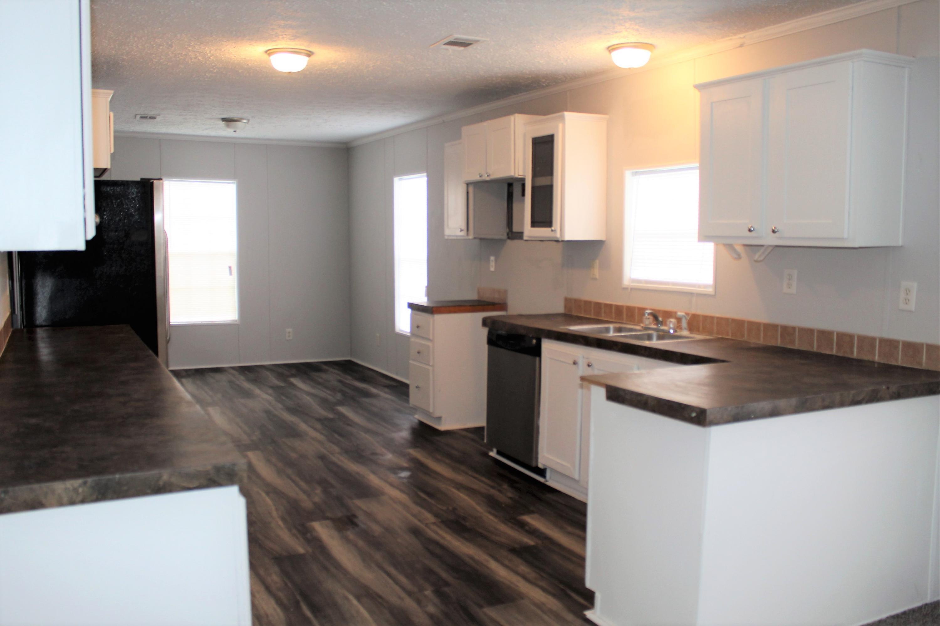 5072 Griffith Mill Road Holt, FL 32564 - Photo 5 of 22 a kitchen with granite countertop a stove a sink and a refrigerator