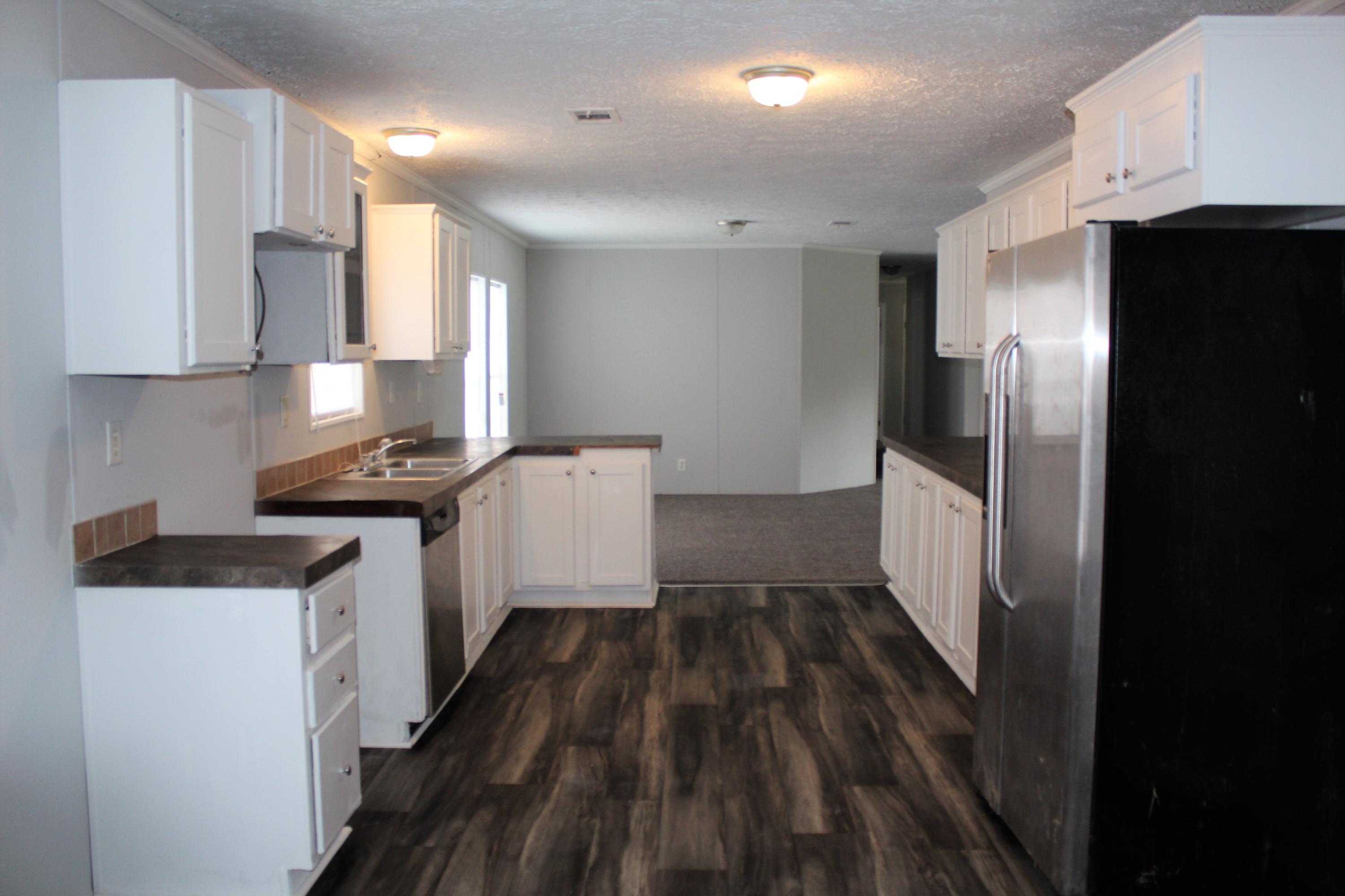 5072 Griffith Mill Road Holt, FL 32564 - Photo 6 of 22 a kitchen with a sink a refrigerator freezer a stove top oven a counter space and wooden floor