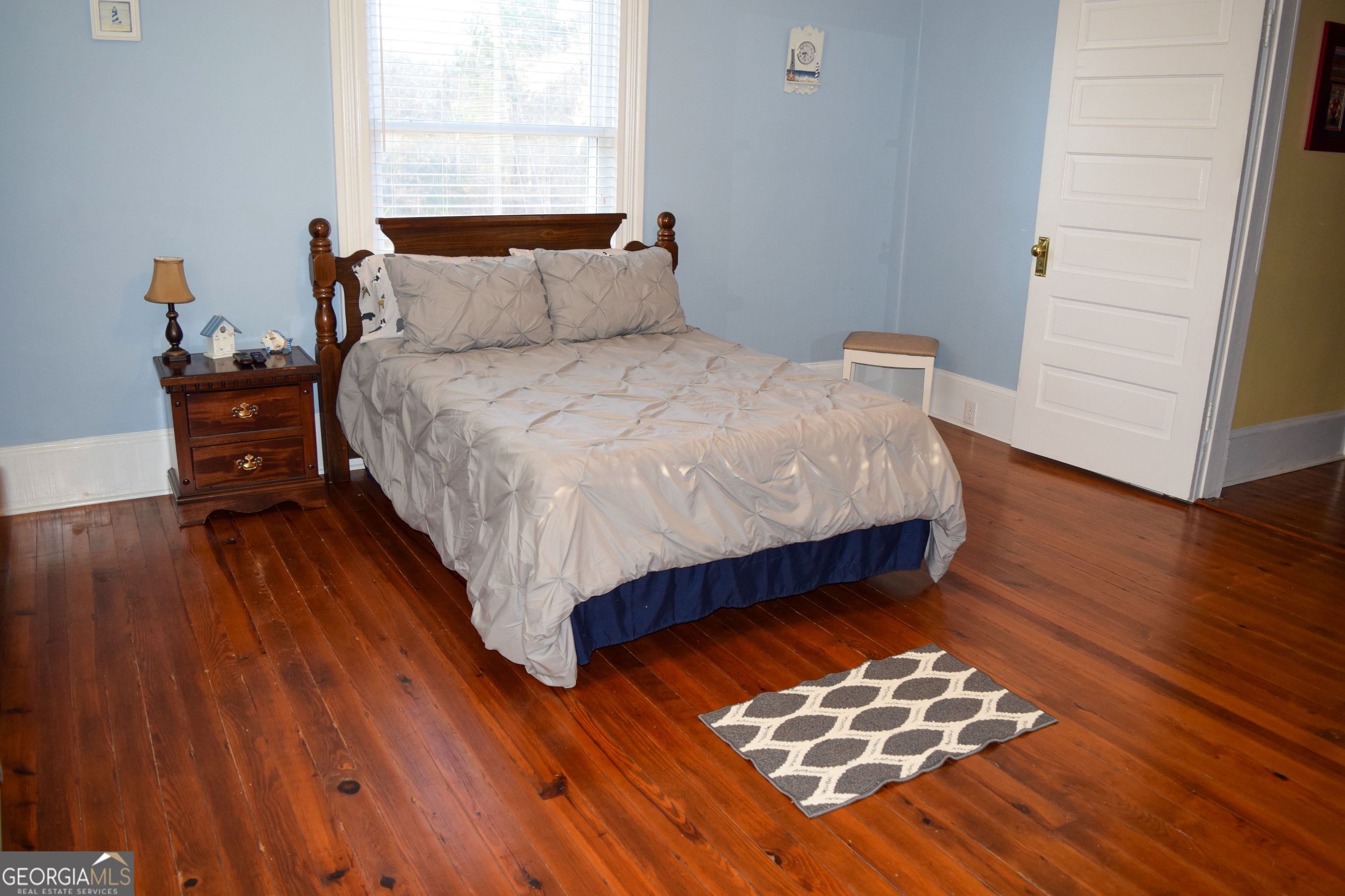 6464 Danburg Road Tignall, GA 30668 - Photo 17 of 23 a bed sitting in a bedroom next to a window with wooden floor