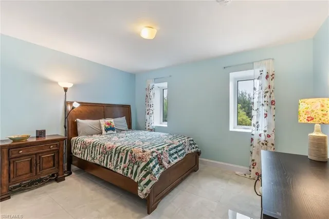 a bedroom with a bed and a lamp on the dresser