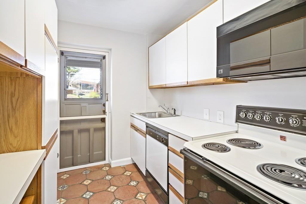 23 Hammond Pond Parkway, Unit 2 Newton, MA 02467 - Photo 18 of 21 a kitchen with a stove and a microwave