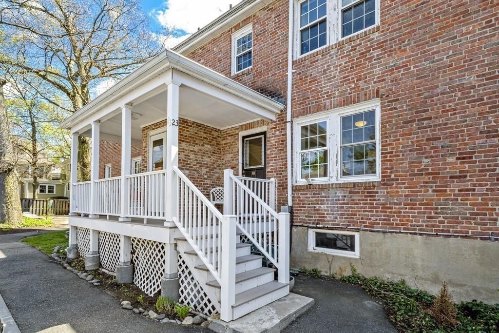 23 Hammond Pond Parkway, Unit 2 Newton, MA 02467 - Photo 19 of 21 a view of a brick house with a large windows stairs and a large tree