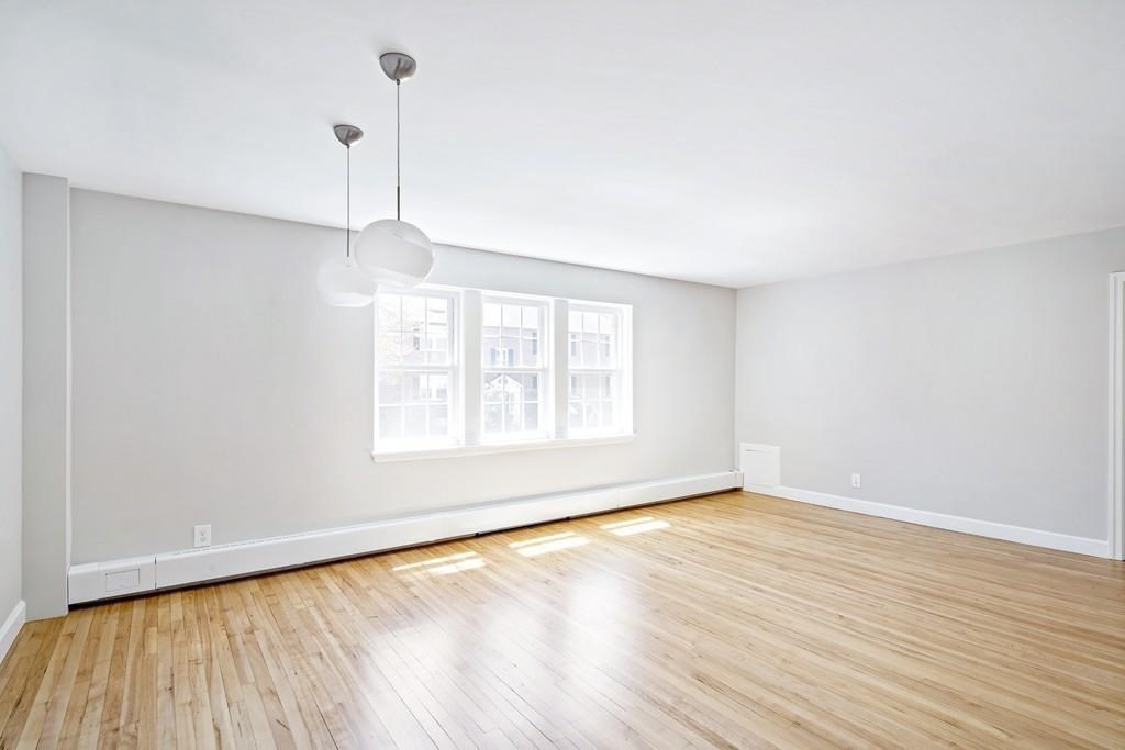 23 Hammond Pond Parkway, Unit 2 Newton, MA 02467 - Photo 5 of 21 a view of an empty room with wooden floor and a window