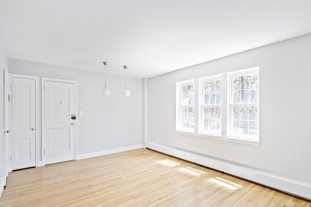 23 Hammond Pond Parkway, Unit 2 Newton, MA 02467 - Photo 7 of 21 a view of an empty room with wooden floor and a window