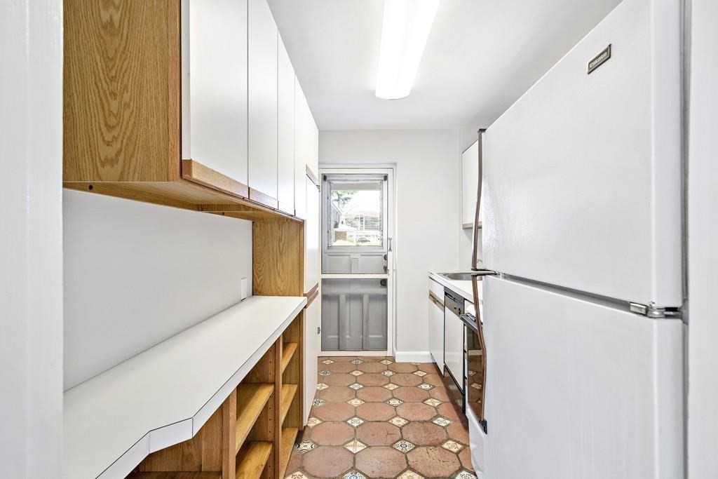 23 Hammond Pond Parkway, Unit 2 Newton, MA 02467 - Photo 10 of 21 a kitchen with a refrigerator and a stove