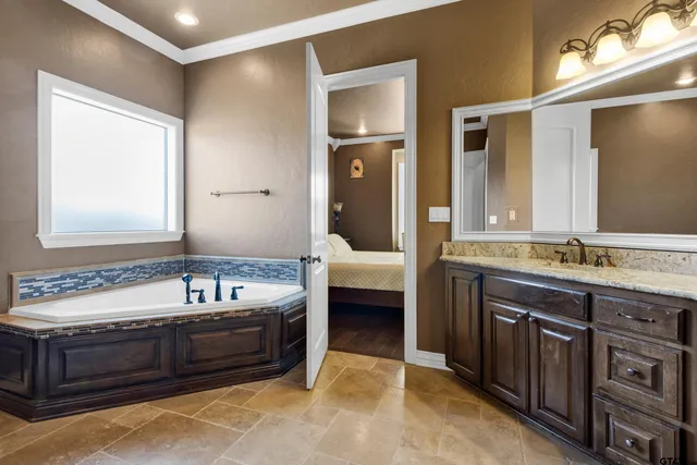 a bathroom with a tub sink and mirror