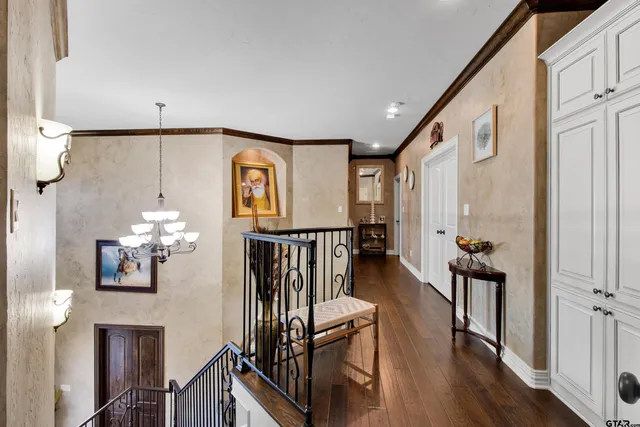 a view of a hallway with wooden floor and staircase