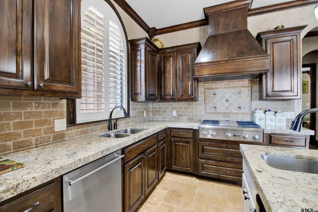 a kitchen with granite countertop a sink stove and cabinets