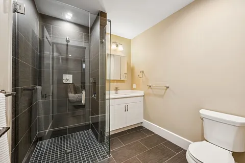 a bathroom with a granite countertop sink toilet and shower