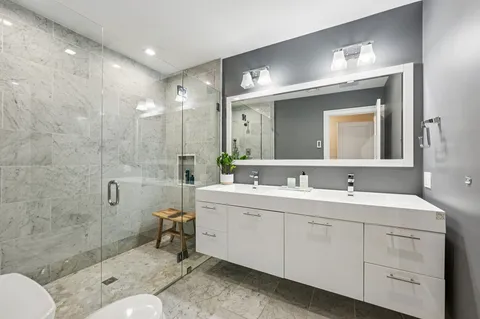 a spacious bathroom with a toilet sink double and mirror