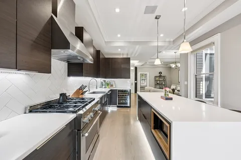 a kitchen with a stove and a wooden floor