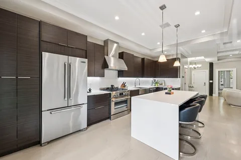 a kitchen with a refrigerator a oven and a sink