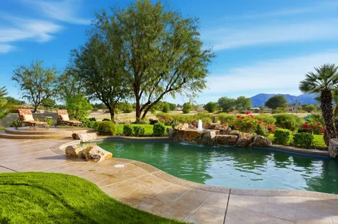 a lake view with a bench and trees around