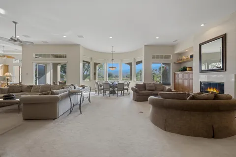 a living room with fireplace furniture and a large window