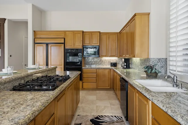 a kitchen with granite countertop sink cabinets and stainless steel appliances