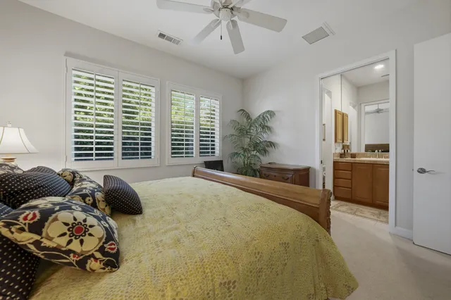 a spacious bedroom with a bed and a potted plant