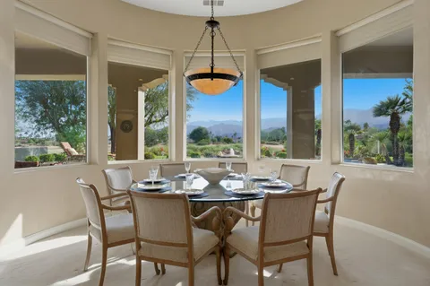 a dining room with furniture a chandelier and wooden floor
