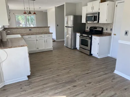 a kitchen with stainless steel appliances kitchen island granite countertop a stove a sink and a refrigerator