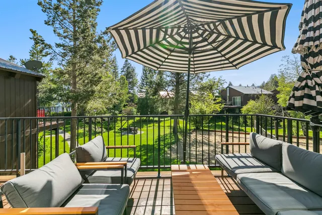 a view of a patio with couches chairs dining table and chairs barbeque grill with wooden fence