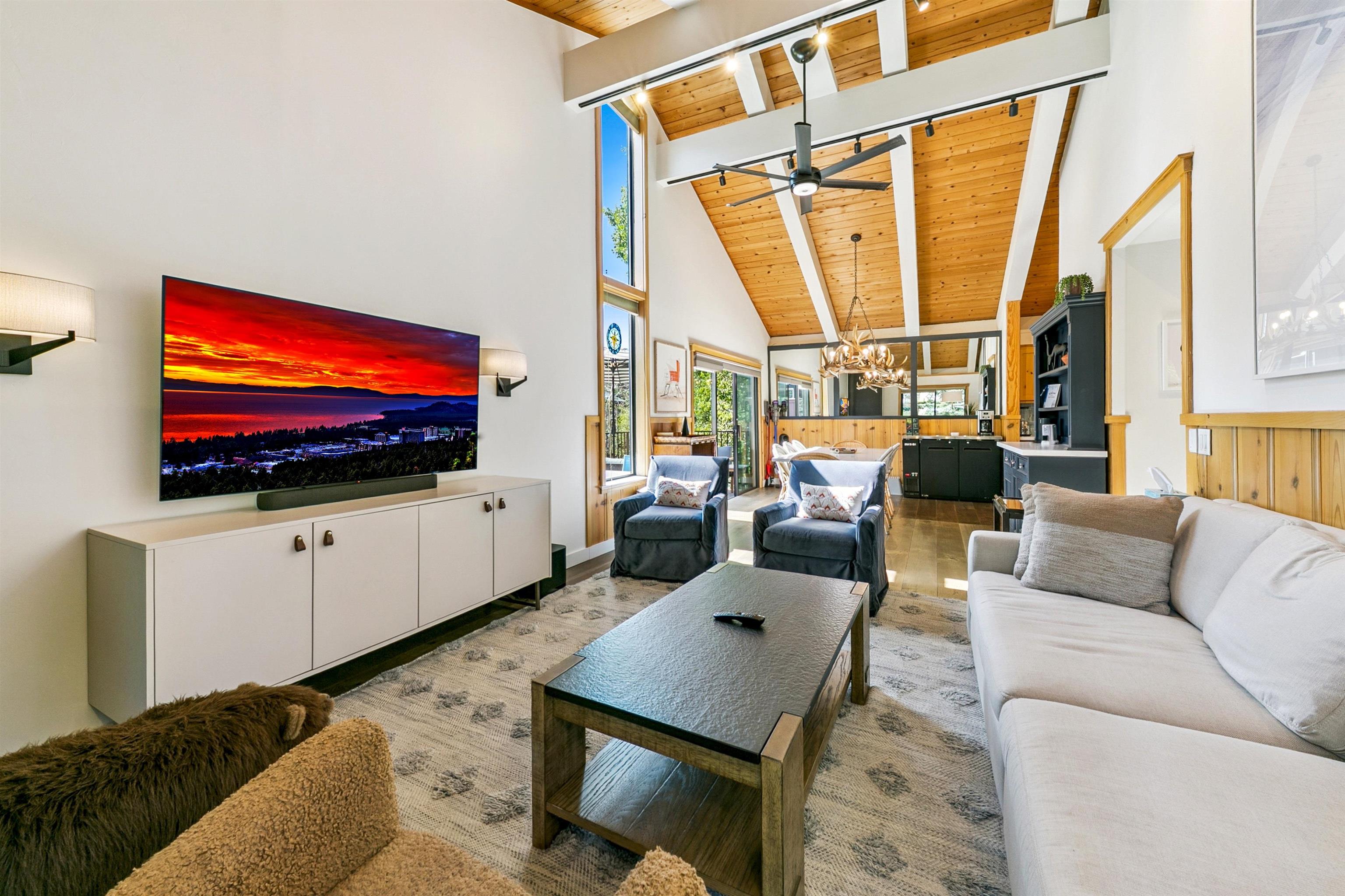 2560 Lake Forest Road, Unit 24 Tahoe City, CA 96145 - Photo 4 of 28 a living room with furniture a flat screen tv and floor to ceiling windows