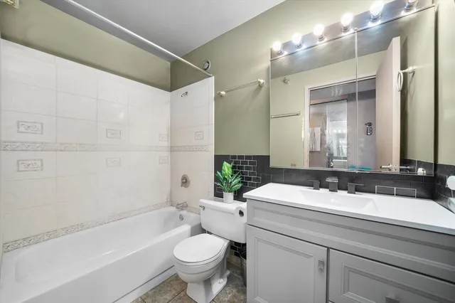 a bathroom with a bathtub shower sink mirror vanity and toilet