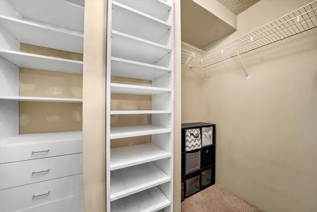 a view of walk in closet with empty racks