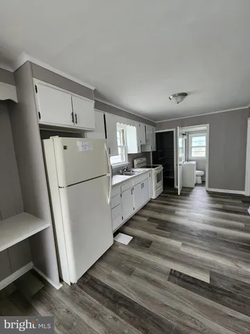 a kitchen with white cabinets and white appliances