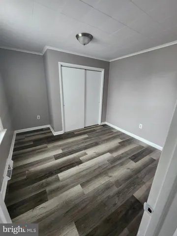a view of a room with wooden floor and a window