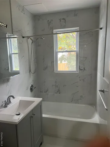 a bathroom with a sink vanity tub and shower
