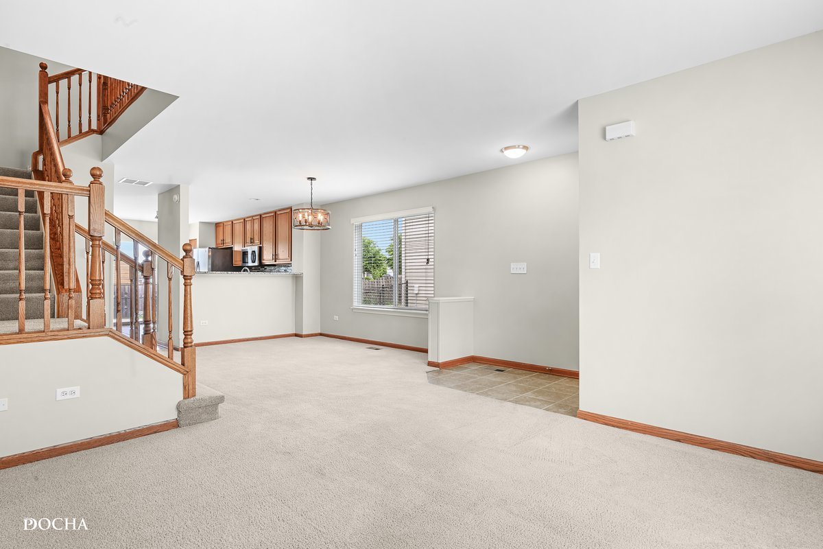2413 Roxbury Lane Montgomery, IL 60538 - Photo 2 of 22 a view of a big room with entryway and stairs