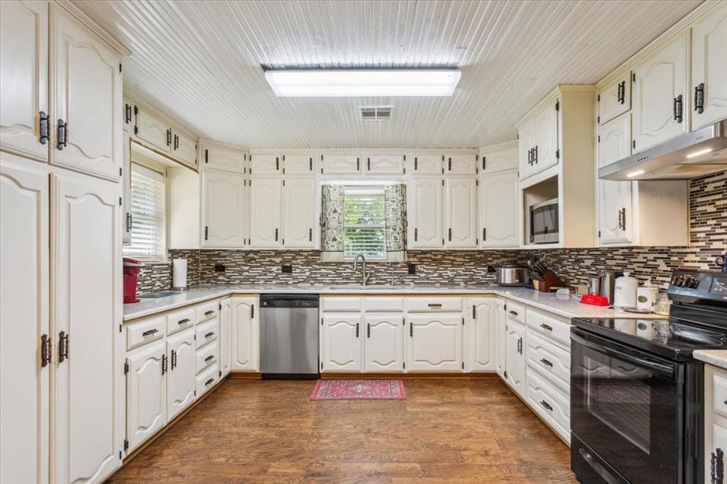 221 County Road 157 Riesel, TX 76682 - Photo 11 of 30 Kitchen featuring stainless steel dishwasher, electric range, under cabinet range hood, a sink, and decorative backsplash