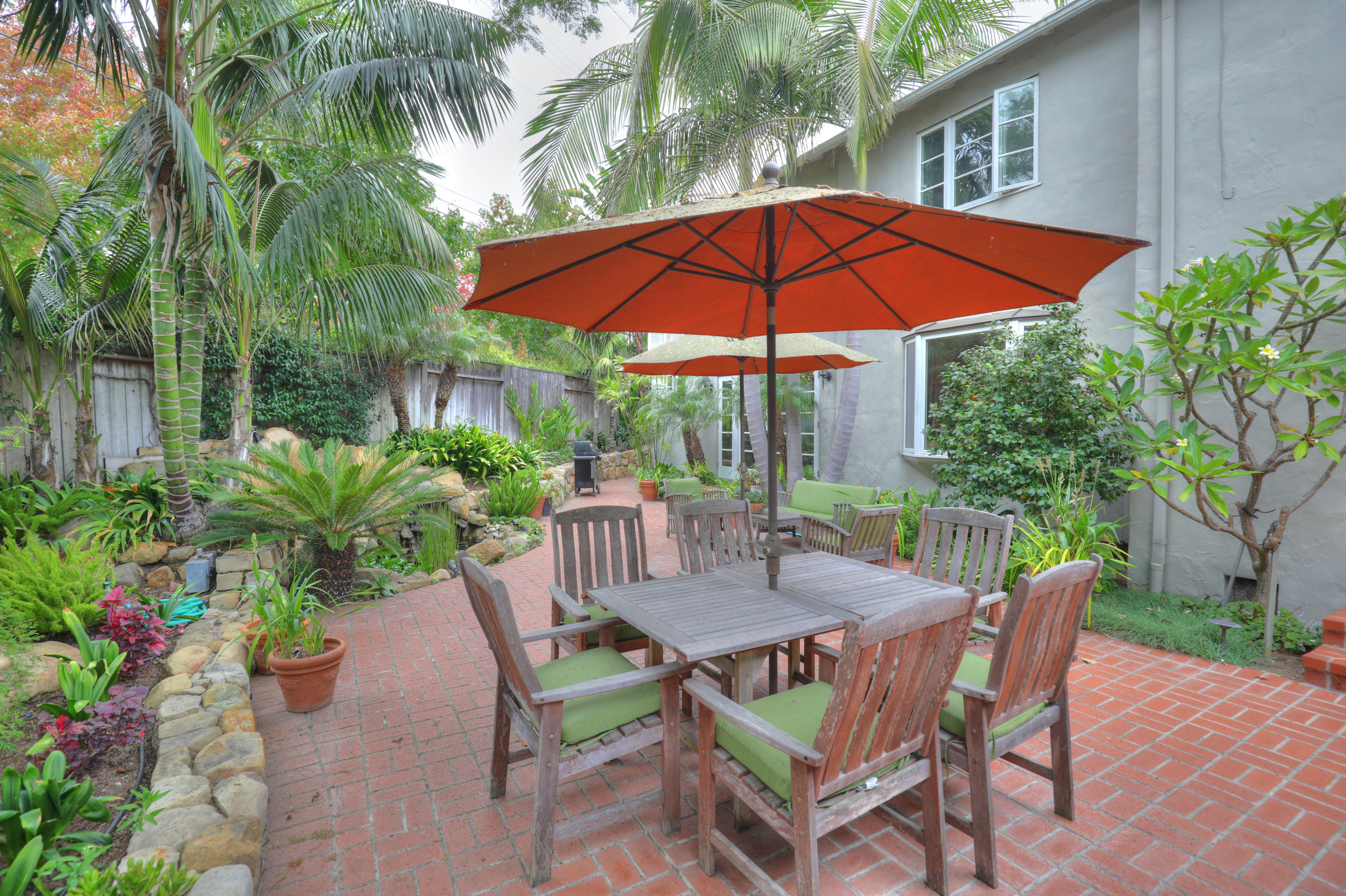 a view of patio with chairs and table under an umbrella