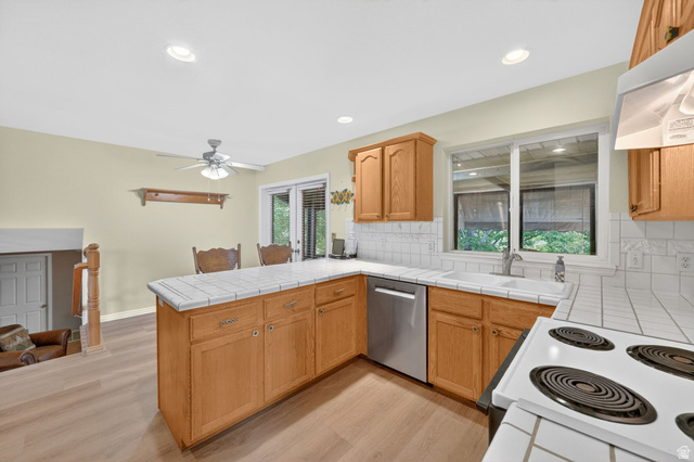 1464 990 West Provo, UT 84601 - Photo 14 of 41 Kitchen featuring wood-finish cabinetry, tile countertops, and a white tile backsplash