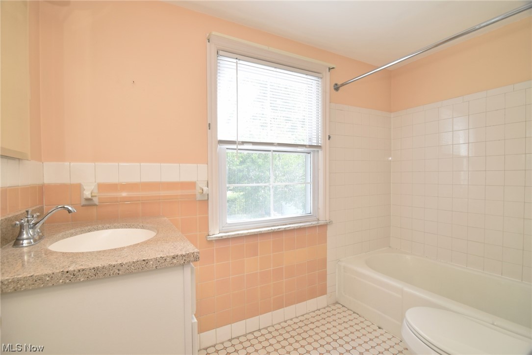 2295 Loyola Road Cleveland, OH 44118 - Photo 24 of 34 Full bathroom featuring light tile flooring, tile walls, tiled shower / bath, and vanity