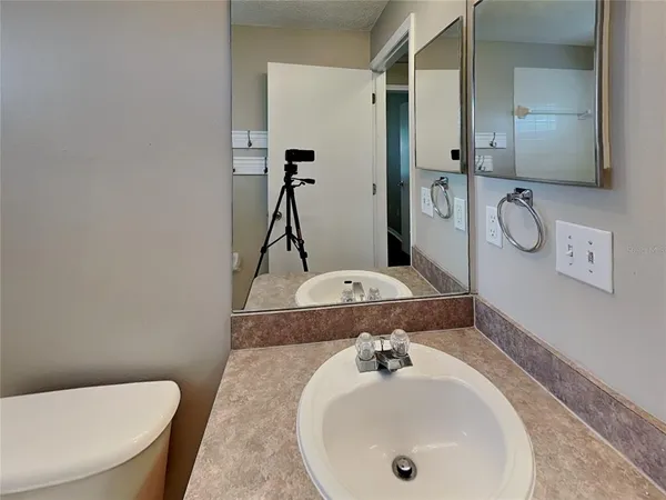 a bathroom with a granite countertop sink a toilet and mirror