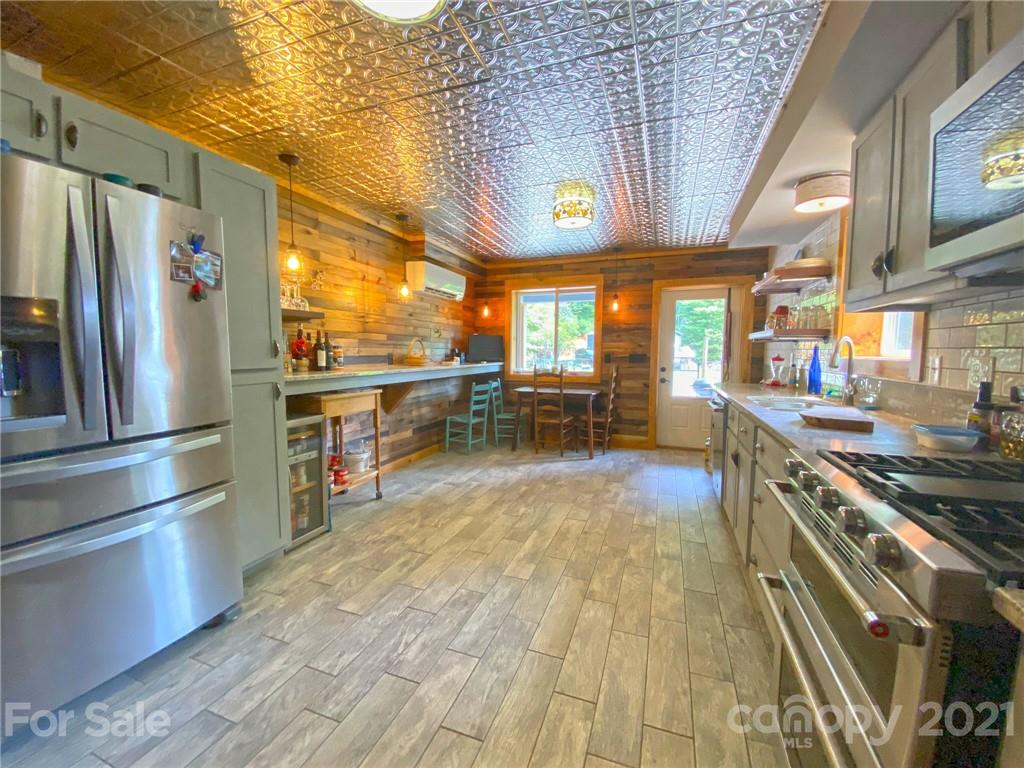 a kitchen with stainless steel appliances a stove a refrigerator and wooden floor