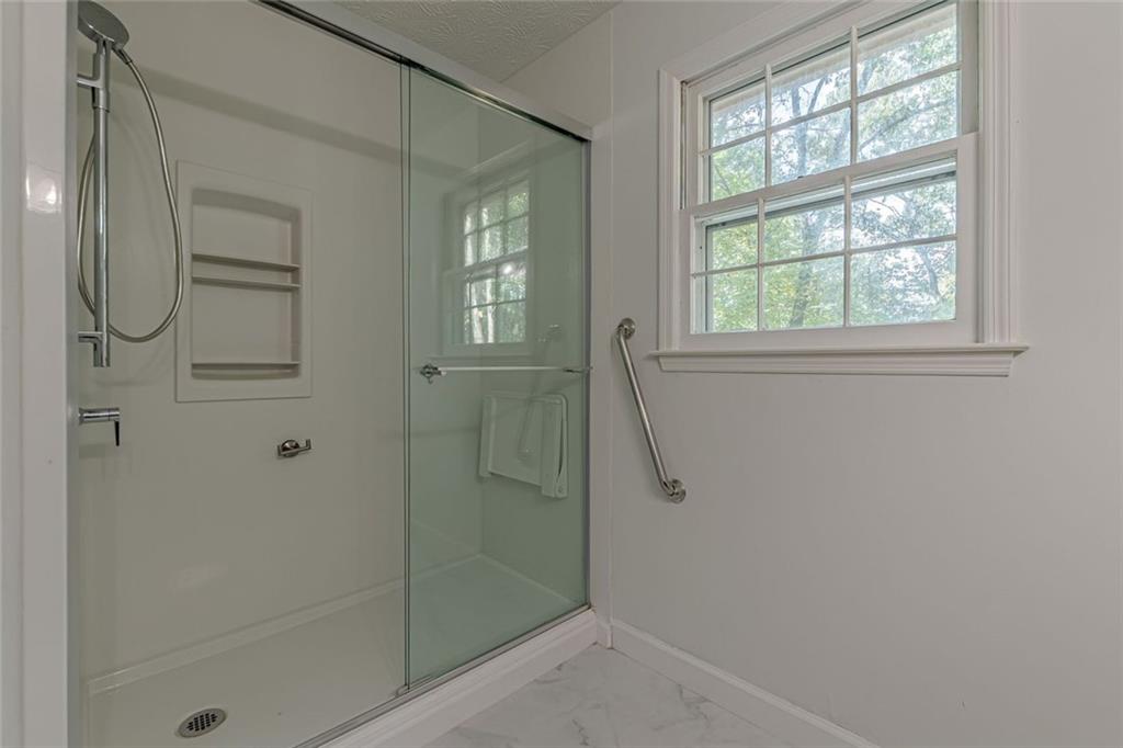 2011 Old Peachtree Road Northwest Duluth, GA 30097 - Photo 17 of 37 a bathroom with a glass shower door