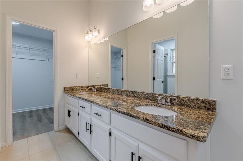 2011 Old Peachtree Road Northwest Duluth, GA 30097 - Photo 22 of 37 a bathroom with a granite countertop sink and a mirror
